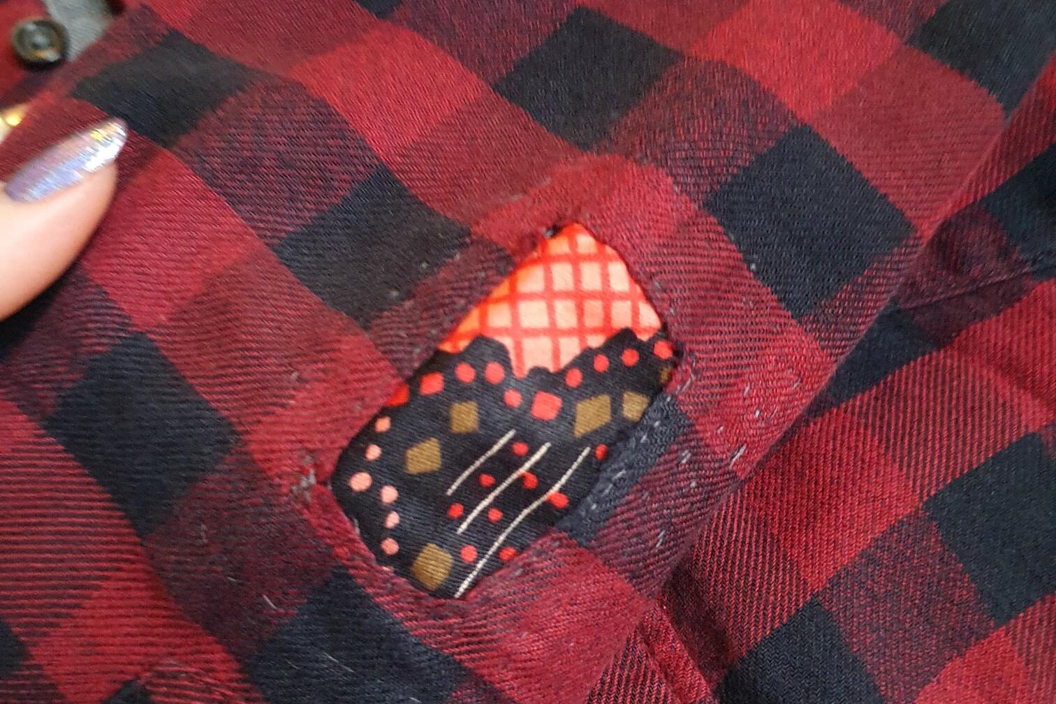 Zoomed in picture of visibly mended shirt elbow.